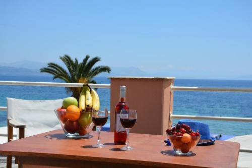 una mesa con dos copas de vino y un tazón de fruta en Alexandra Apartment, en Ýpsos