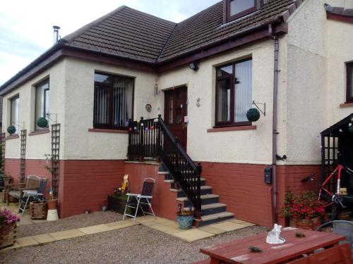 a house with a staircase in front of it at Melrose in Fort William