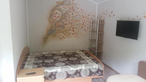 1 dormitorio con 1 cama y una pintura en la pared en Ošupio poilsis, en Šventoji