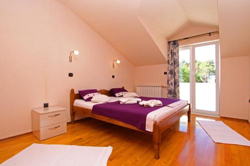 Un dormitorio con una cama con sábanas moradas y una ventana en Apartment Beach, en Split