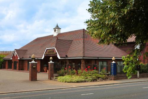 a building with a clock tower on top of it at Best Western Manor Hotel in Gravesend