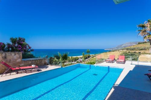 a swimming pool with a view of the ocean at Sea View Villas in Episkopí- Rethimno