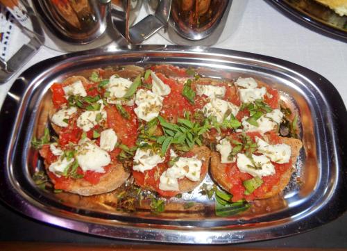 a pizza with cheese and tomatoes on a pan at Menina Farm Kalamata Countryside in Perivolákia