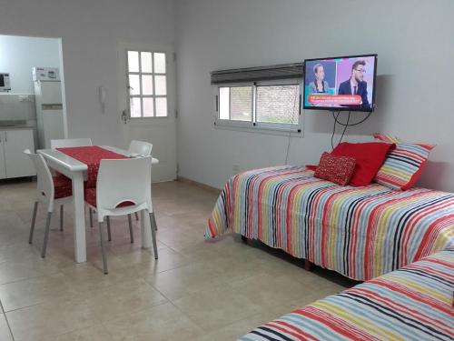 1 dormitorio con cama, mesa y TV en "Los Abrojos" 1 en Santa Rosa