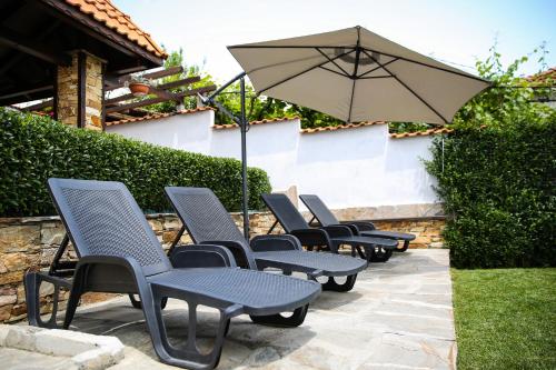 - une rangée de chaises et un parasol sur la terrasse dans l'établissement House of Time, à Ognyanovo