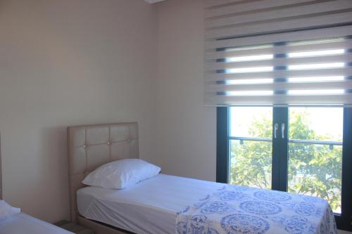 ArsinにあるSeyran Seasideのベッドルーム1室(ベッド1台、ブラインド付きの窓付)