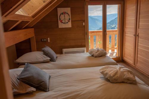 Duas camas num quarto com uma janela em La Cabane de Tim em Muhlbach-sur-Munster