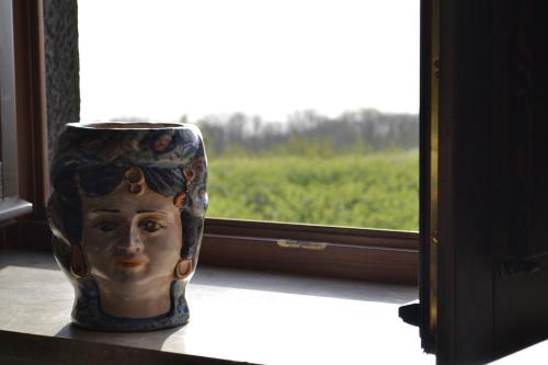 a vase sitting on a shelf next to a window at Bosco Ciancio in Biancavilla
