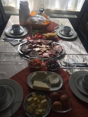 a table topped with plates of food on a table at Pensiunea Domnescu in Sălişte