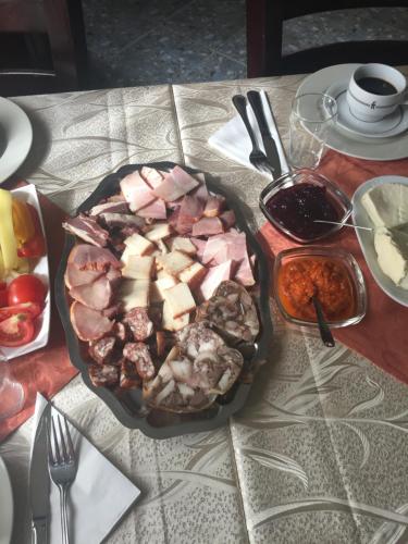 a table with a plate of food on a table at Pensiunea Domnescu in Sălişte