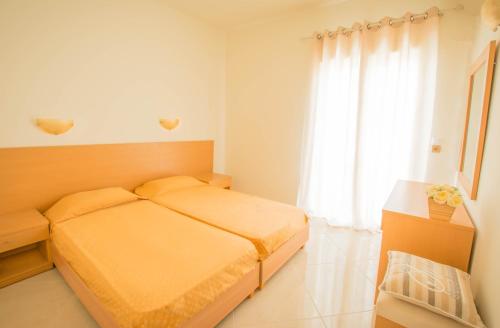 a bedroom with a bed and a large window at Frixos Hotel in Malia