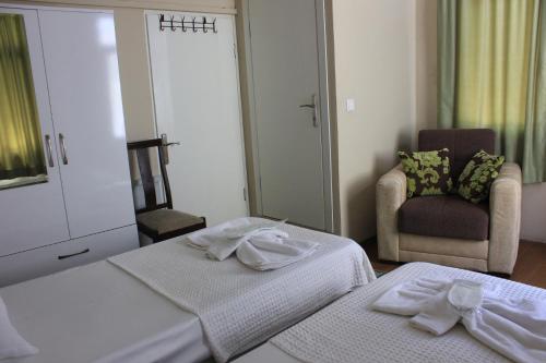 a hotel room with two beds and a chair at Macide Hanım Konağı in Ayvalık