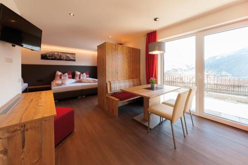 Habitación de hotel con 1 cama, 1 mesa y 1 dormitorio en Apart Josef, en Ladis
