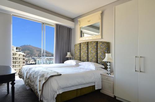 a bedroom with a large bed with a large window at 410 Harbour Bridge in Cape Town