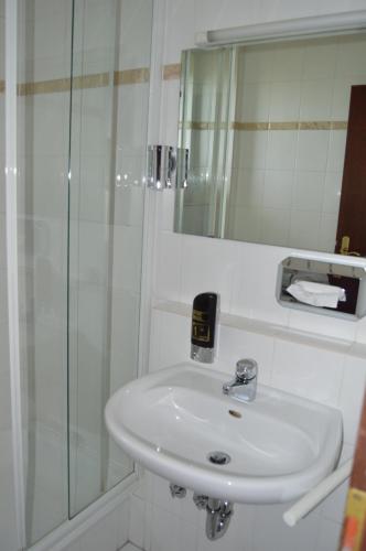 a bathroom with a white sink and a shower at G&H Hotel Rosengarten in Rosengarten