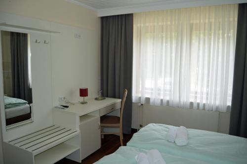 a hotel room with a bed and a desk and a bed and a deskicter at G&H Hotel Rosengarten in Rosengarten