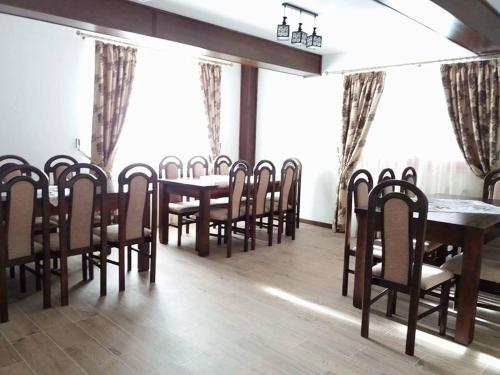 a dining room with wooden tables and chairs at Pensiunea Putnisoara in Putnişoara