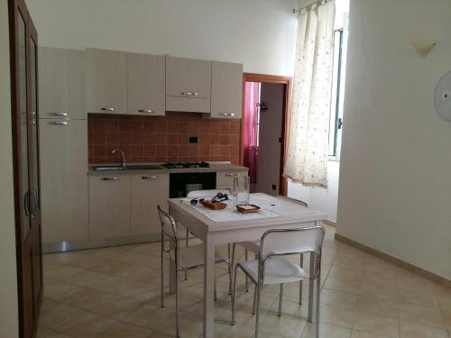 a kitchen with a white table and chairs in it at Appartamento Larghetto Licastro in Pizzo