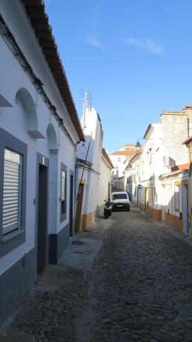 eine Gasse mit weißen Gebäuden und einem Auto auf einer Straße in der Unterkunft Casinha alentejana in Évora
