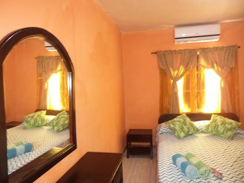 Un dormitorio con dos camas y un espejo. en Posada Nativa Shingle Hill, en San Andrés