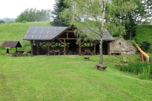 a large building with a solar roof in a field at Penzion Richard in Bělá pod Pradědem