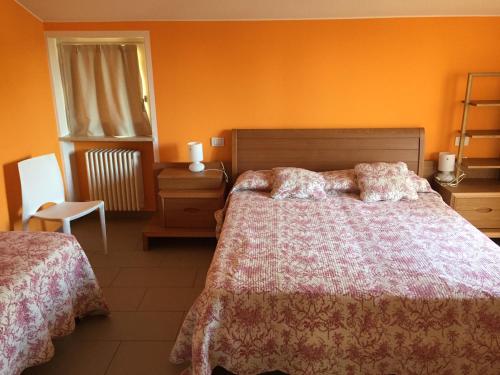 a bedroom with orange walls and a bed and a chair at Villarobinia in Lazise