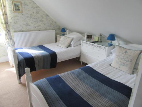 a bedroom with two beds and a dresser at The Langtons in Eastbourne