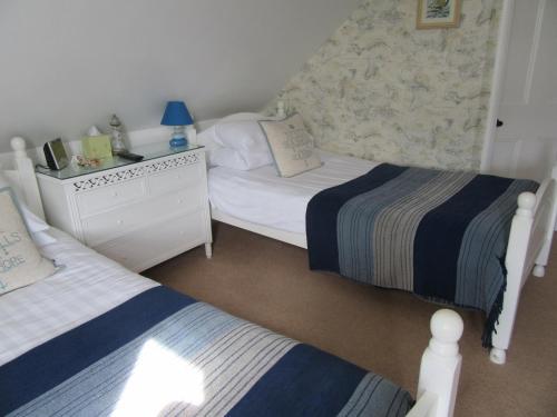 a bedroom with two beds and a dresser at The Langtons in Eastbourne