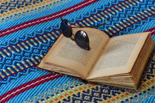 a book with a pair of glasses on top of it at Noble House Essence Évora - by Unlock Hotels in Évora