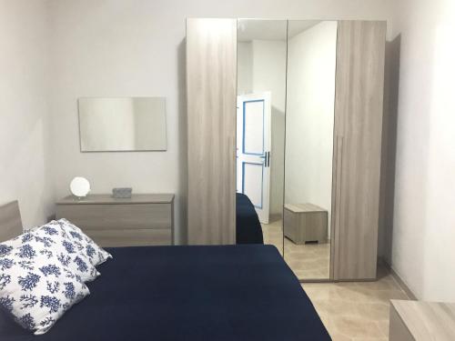 a bedroom with a blue bed and a mirror at Il Maestrale - Immobilevante in Ponza