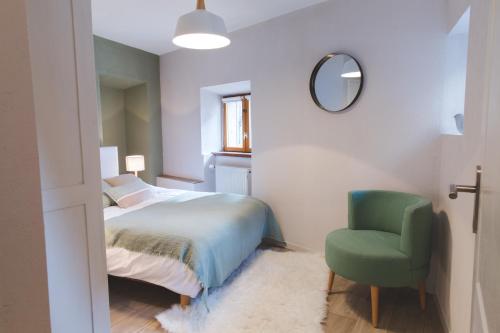 a bedroom with a bed and a green chair at HISSLA ALSACE CHIC& COSY BARR Wine Route in Barr