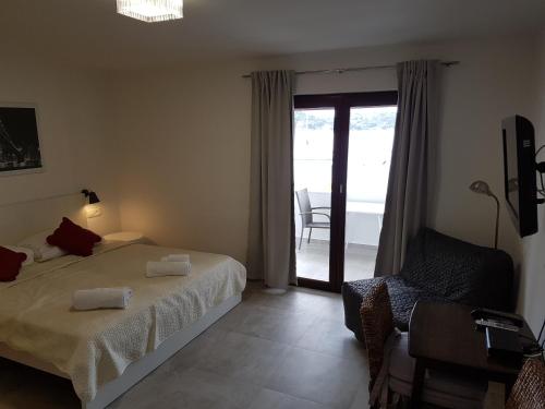 a bedroom with a bed and a sliding glass door at Apartments Antonio in Tisno