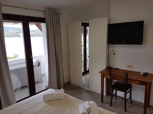 a bedroom with a desk and a television on a wall at Apartments Antonio in Tisno