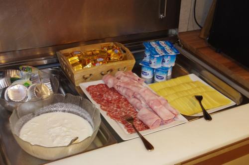 un comptoir avec de la viande, du fromage et d'autres aliments dans l'établissement Logis La Croix-Saint-Maurice, au Grand-Bornand