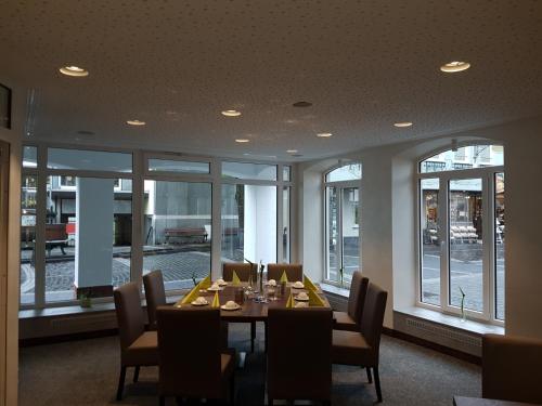 a dining room with a table and chairs and windows at Hotel Ännchen in Bad Neuenahr-Ahrweiler