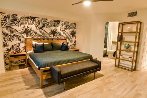 a bedroom with a large bed and a wall with plants at Casa Azul in East End