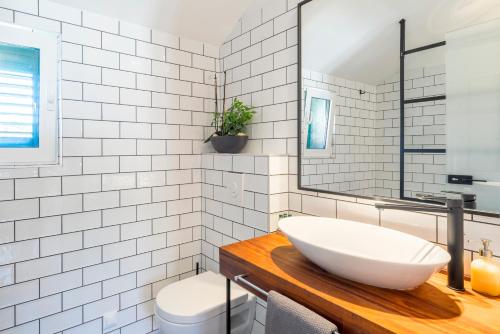 a white bathroom with a sink and a toilet at Kalavanda Apartment in Hvar