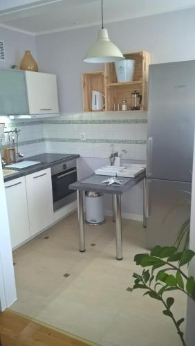 kuchnia ze stołem, zlewem i lodówką w obiekcie No.1 Apartments - Kołobrzeg Beach Centrum w Kołobrzegu