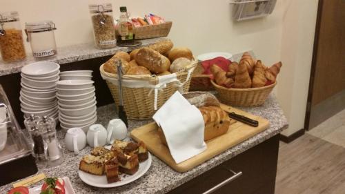 a kitchen counter with bread and baskets of pastries at Hotel Ännchen in Bad Neuenahr-Ahrweiler