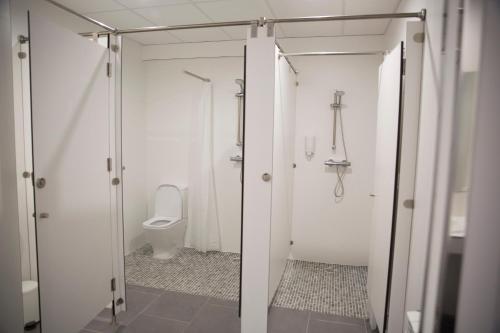 a white bathroom with a toilet and a shower at Albergue Camiño Do Sar in Padrón