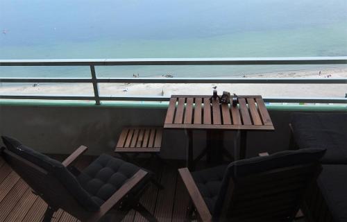 uma mesa e cadeiras numa varanda com vista para a praia em Mehr Meer geht nicht em Sierksdorf