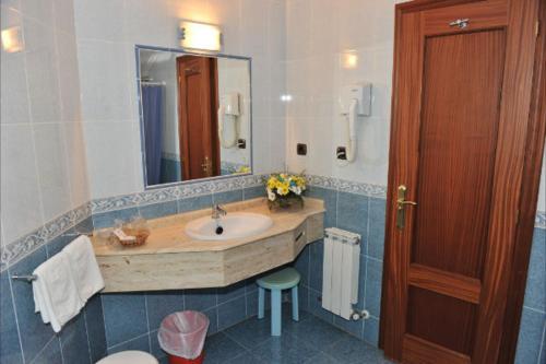 W łazience znajduje się umywalka i lustro. w obiekcie Hotel Alfar w mieście Isla