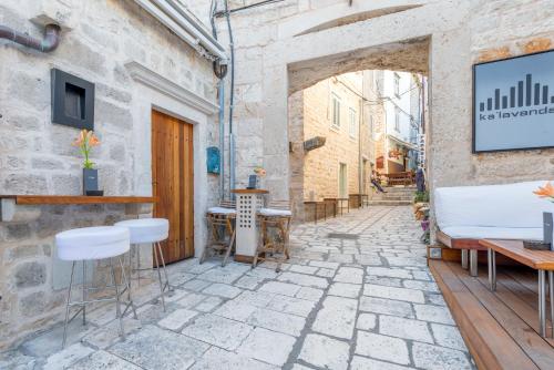 an alley with tables and chairs in a building at Kalavanda Apartment in Hvar