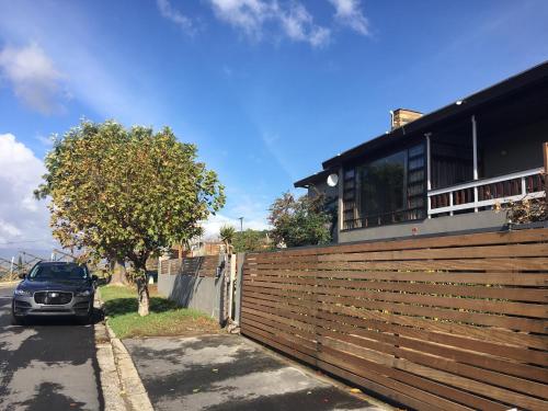 a car parked next to a fence in front of a house at A' Queenslin Guesthouse in Paarl