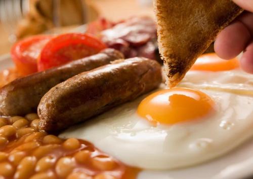 a plate of food with eggs beans and sausage at Heights Hotel in Portland