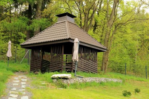 a small building with a roof with an umbrella at Boutique Hotel Sudetia - Medical & SPA in Świeradów-Zdrój