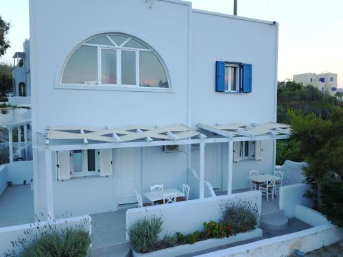 a white house with a window and a patio at Unique Galini Oia - Adults Only in Oia