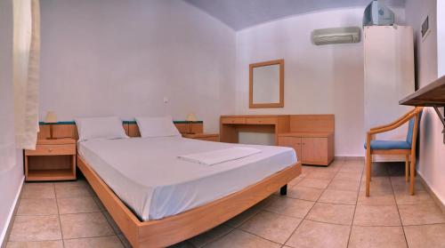 a bedroom with a bed and a desk and a chair at Pefka Rooms in Mytilini