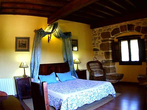 a bedroom with a bed with blue pillows at Palacio de los Alvarado in El Ribero