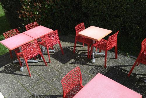 a group of tables and chairs with pink tables at Premiere Classe Strasbourg Ouest in Strasbourg